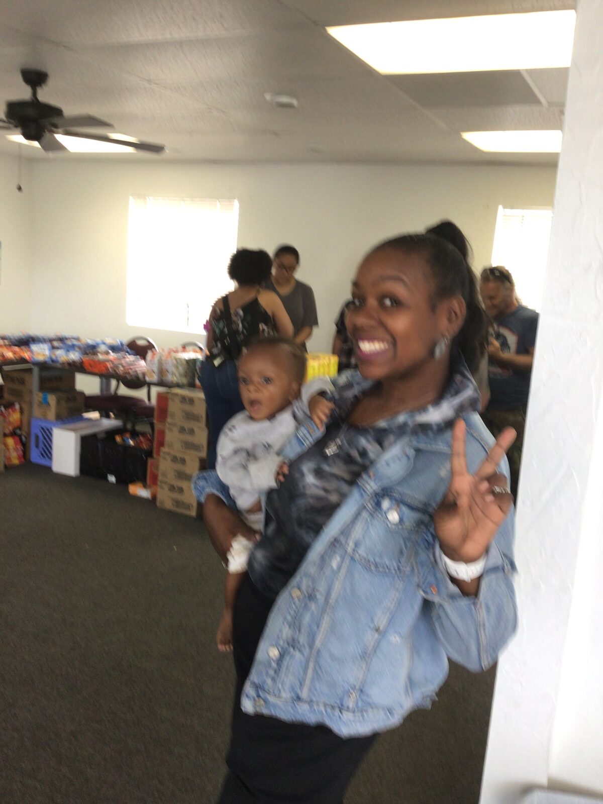 A mother and her baby smiling at a Manna Impact pantry event